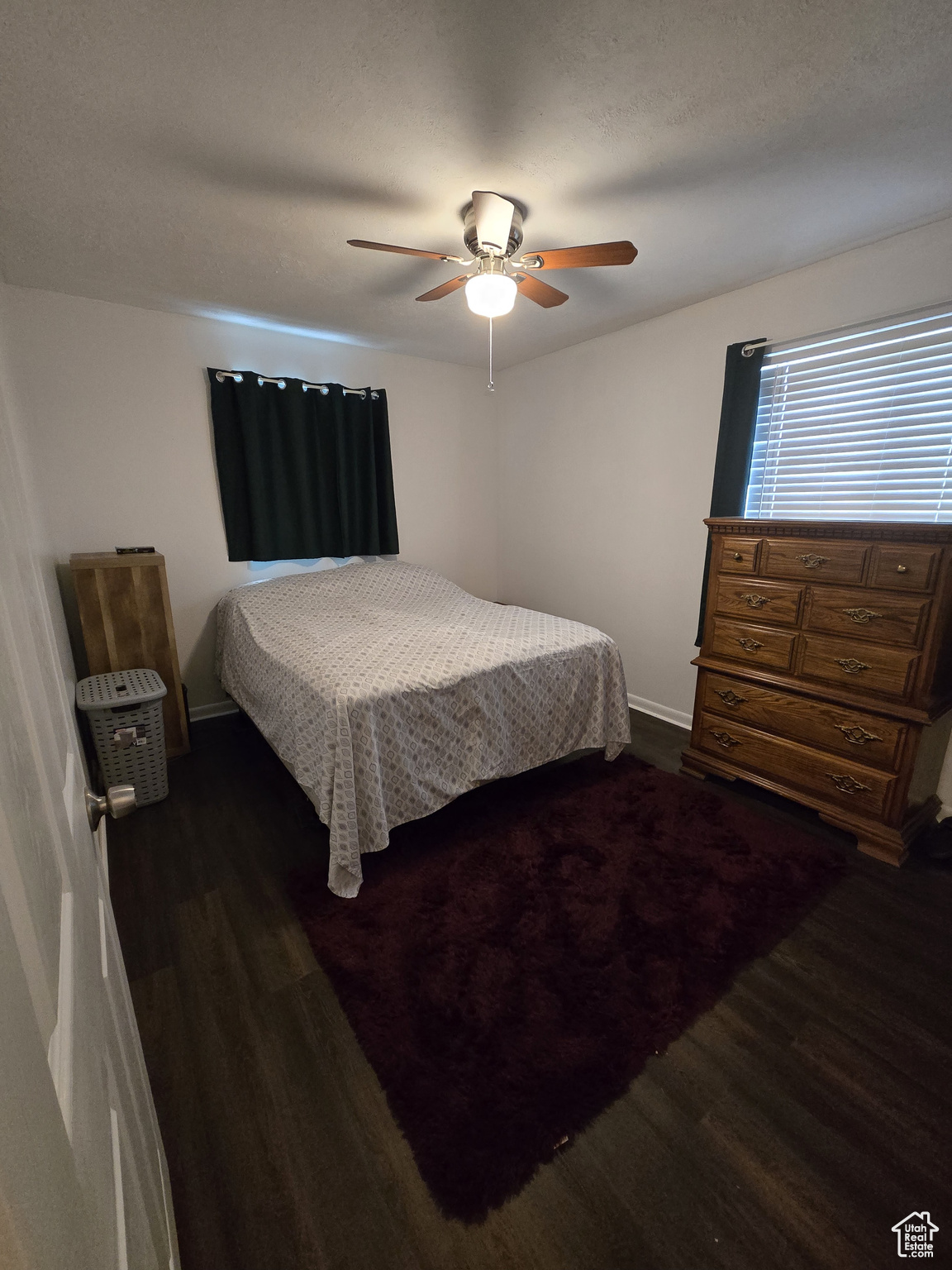 Bedroom featuring ceiling fan and dark wood-type flooring