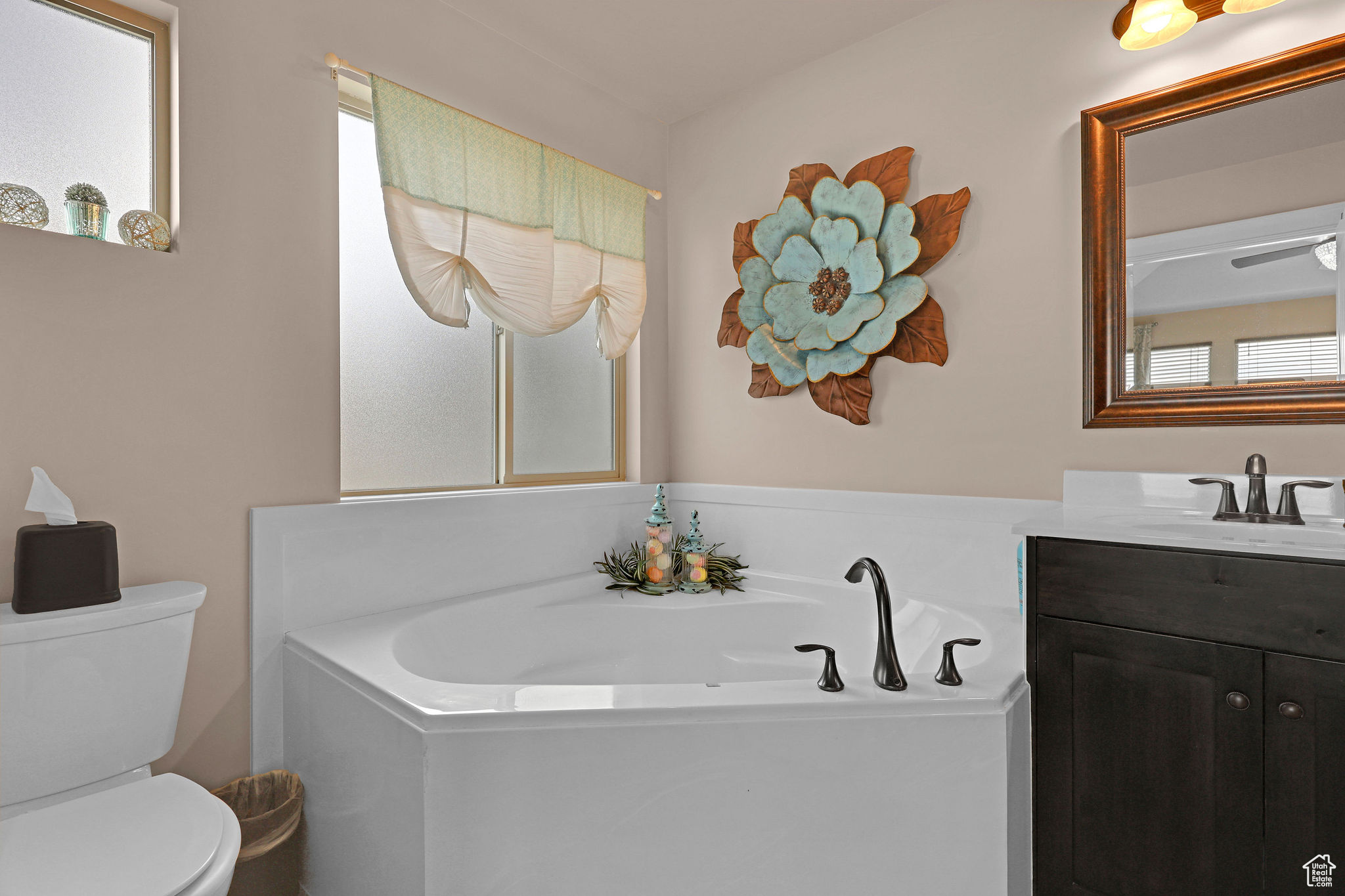 Bathroom with a tub to relax in, vanity, and toilet