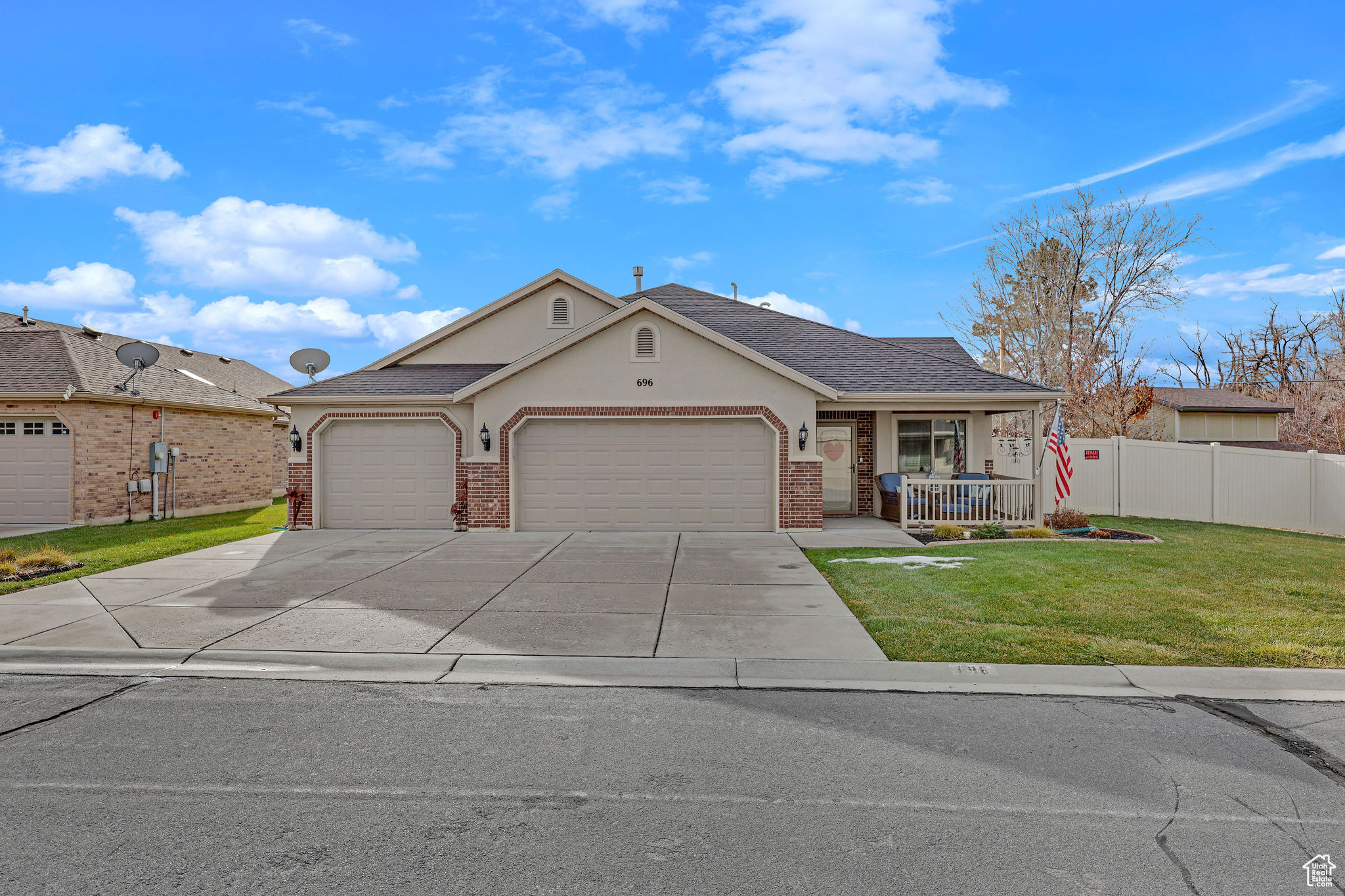 Ranch-style home with a front lawn, a porch, and a garage