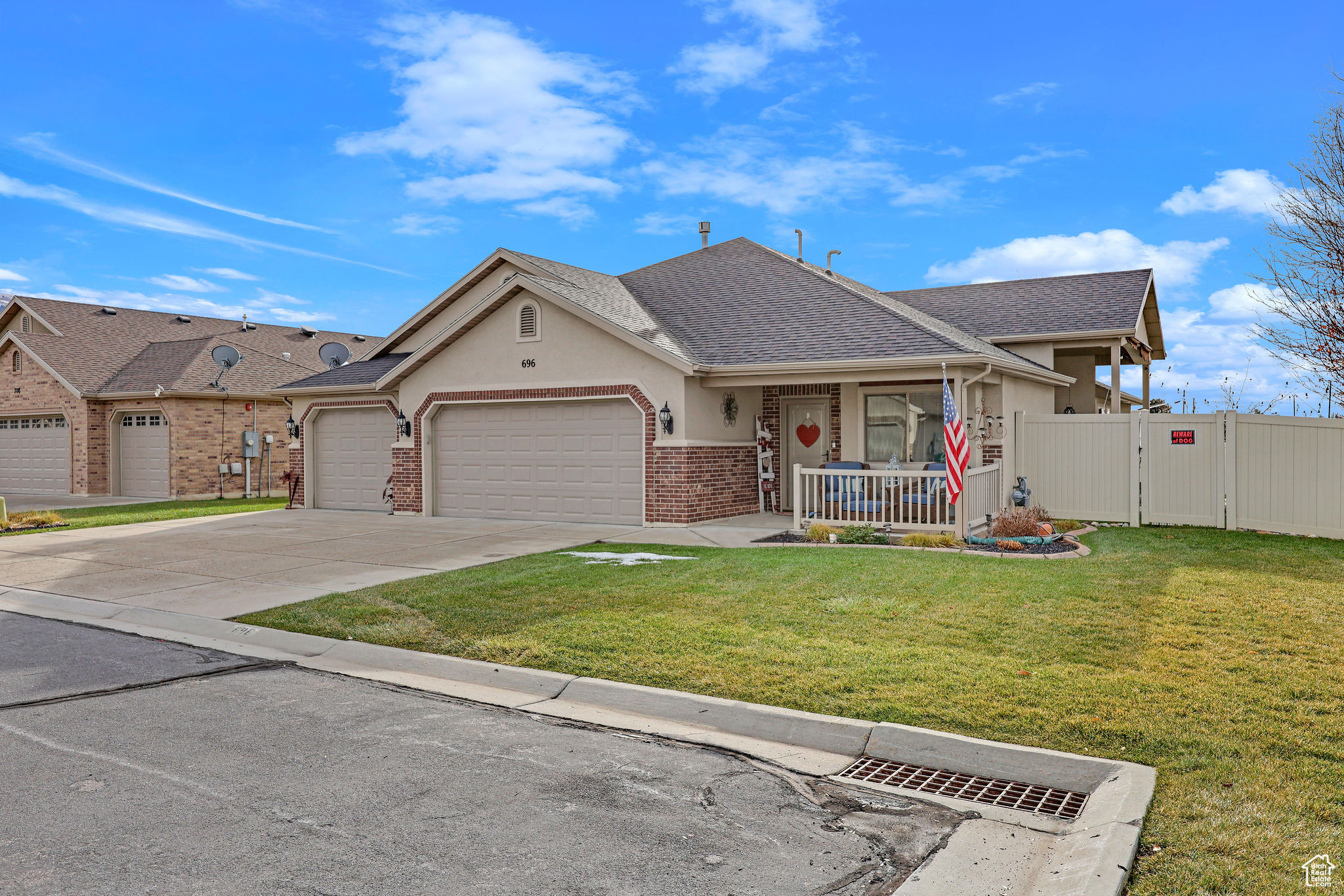 View of front of house featuring a front lawn, a porch, and a garage