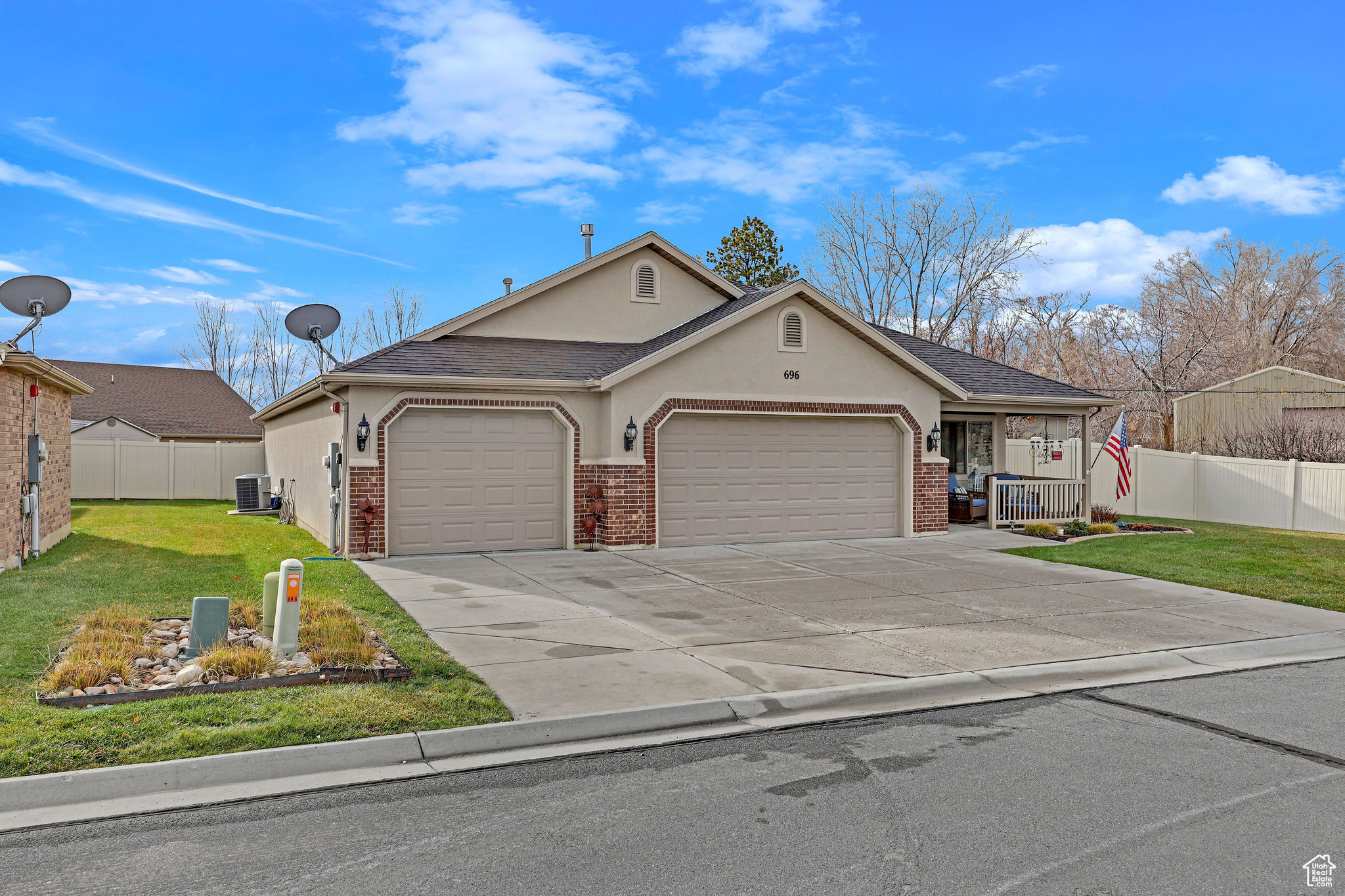 View of front of property with a garage, central air condition unit, and a front yard