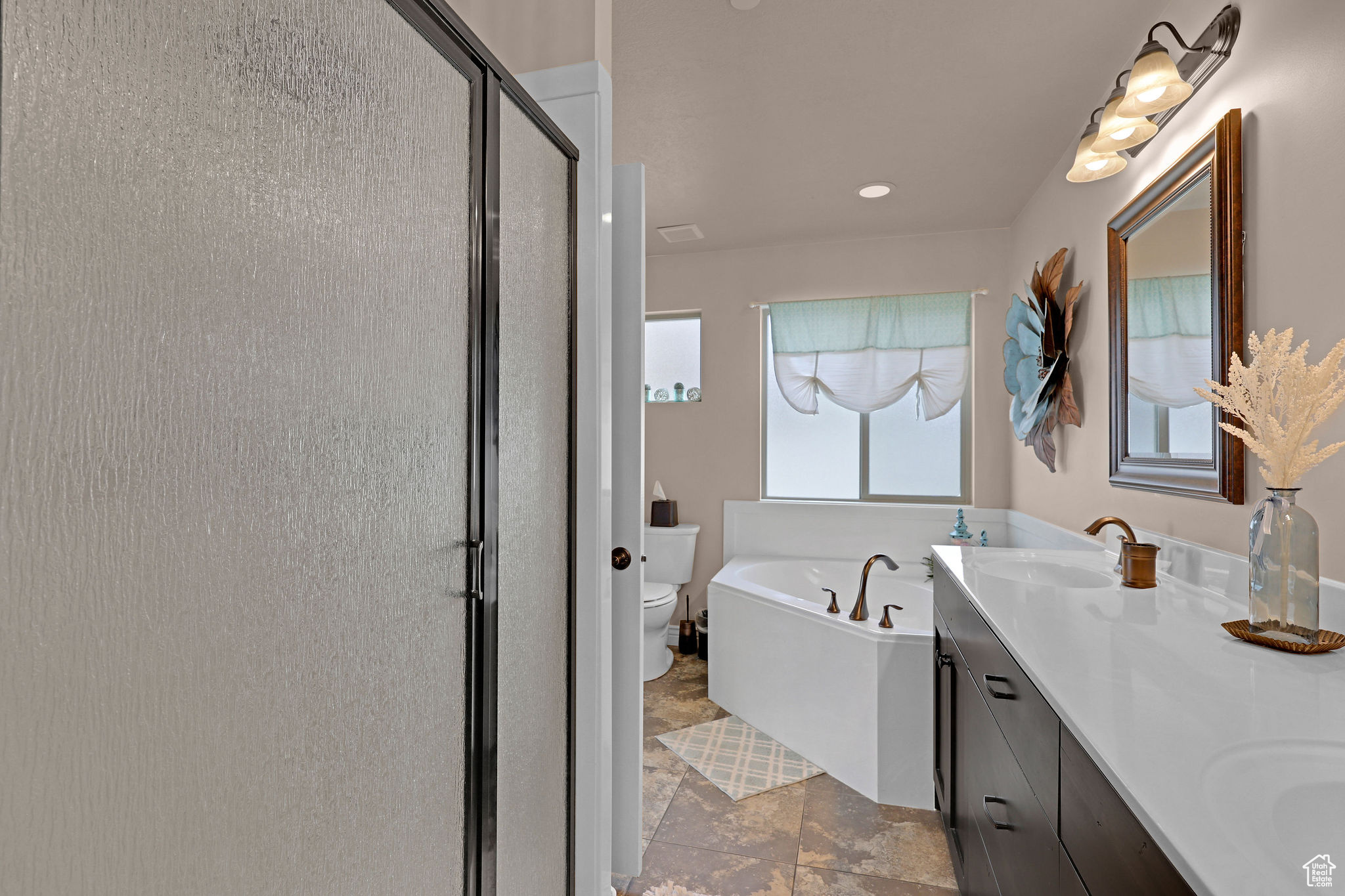 Full bathroom featuring vanity, toilet, and shower with separate bathtub