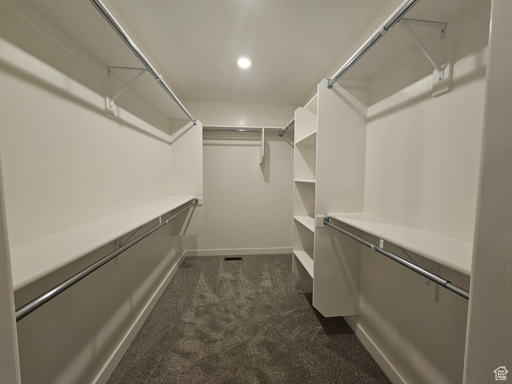 Walk in closet with dark carpet