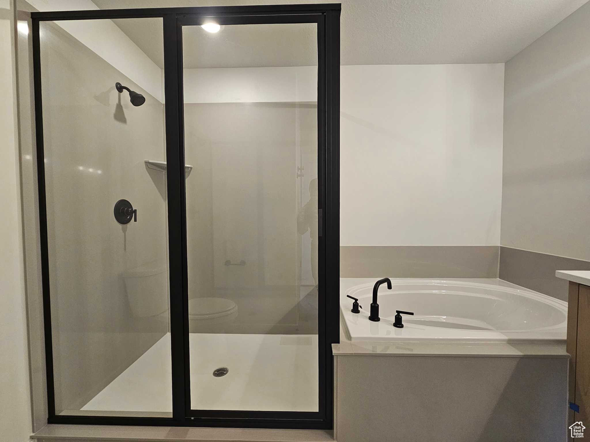 Bathroom with vanity, a textured ceiling, and shower with separate bathtub