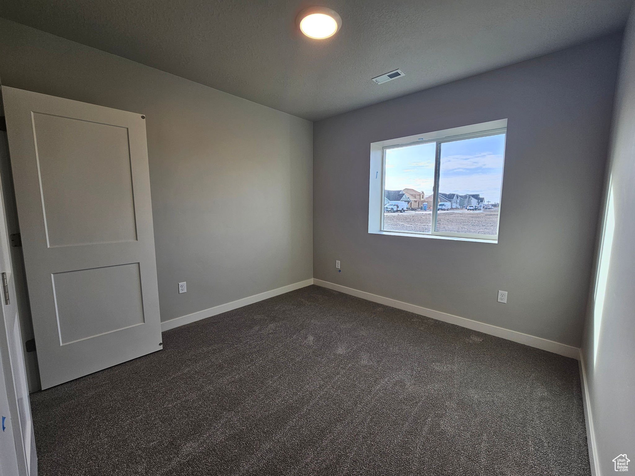 Empty room with dark colored carpet