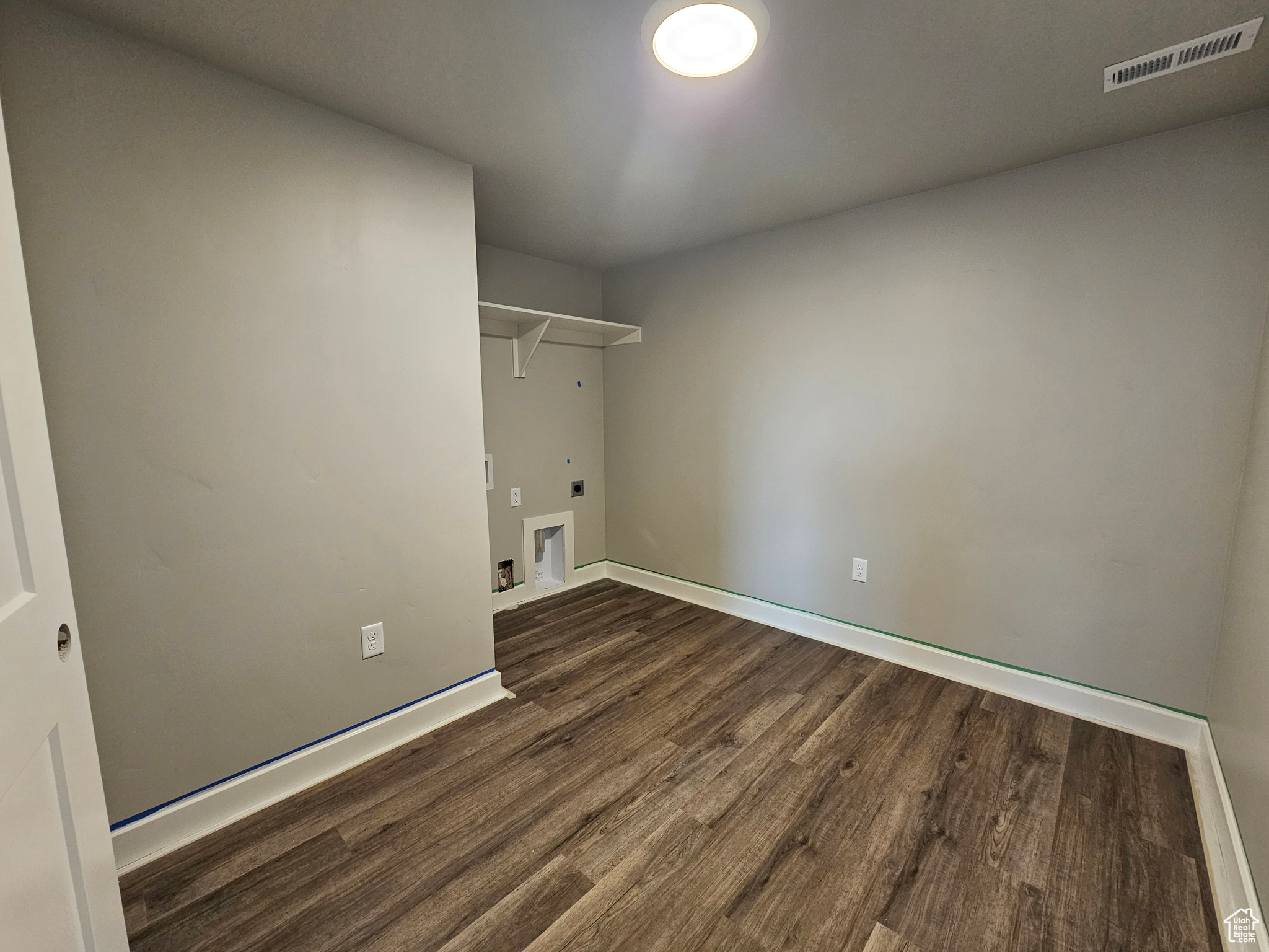 Laundry area with hookup for an electric dryer, washer hookup, and dark hardwood / wood-style floors