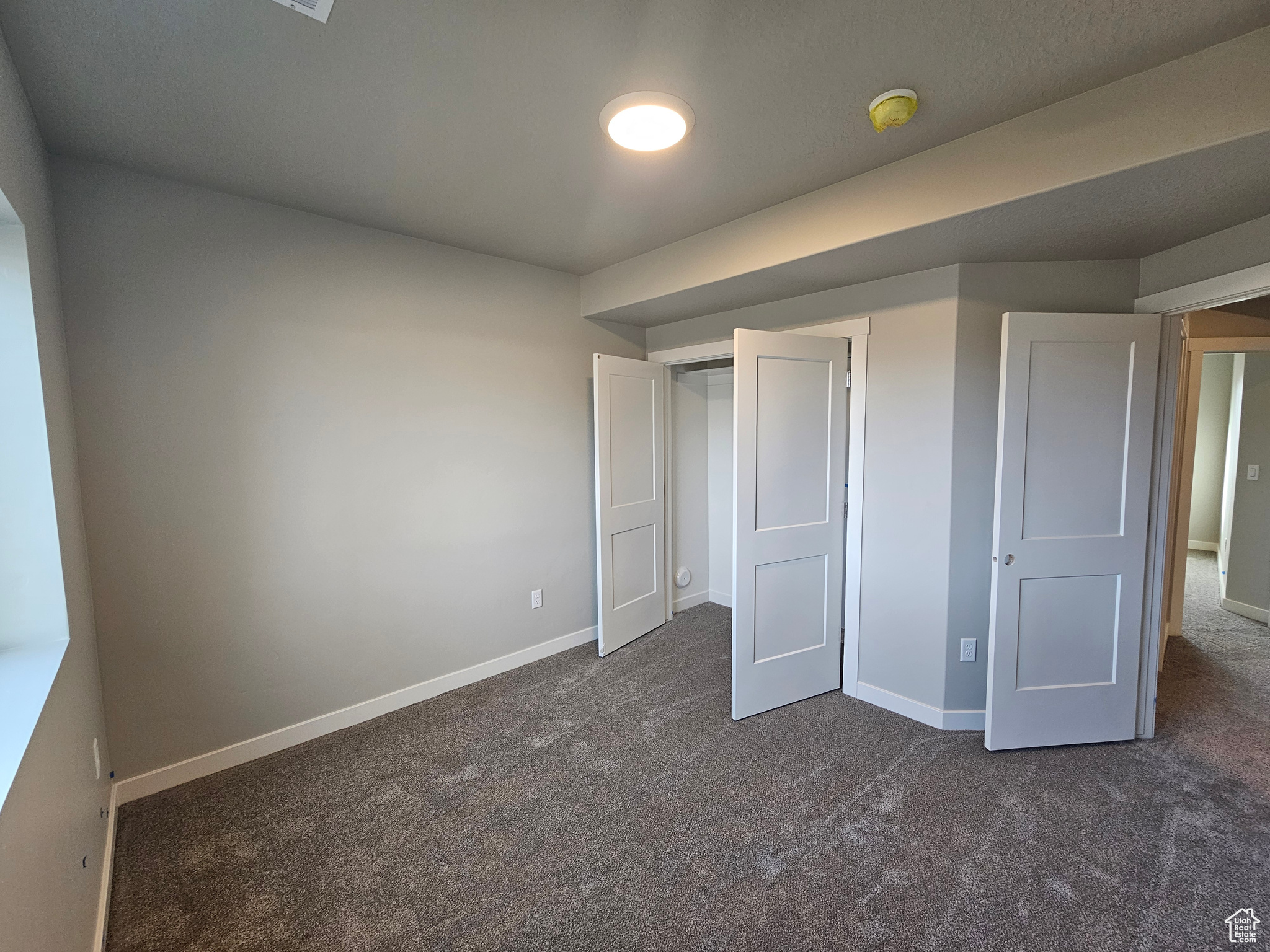 Unfurnished bedroom featuring dark colored carpet