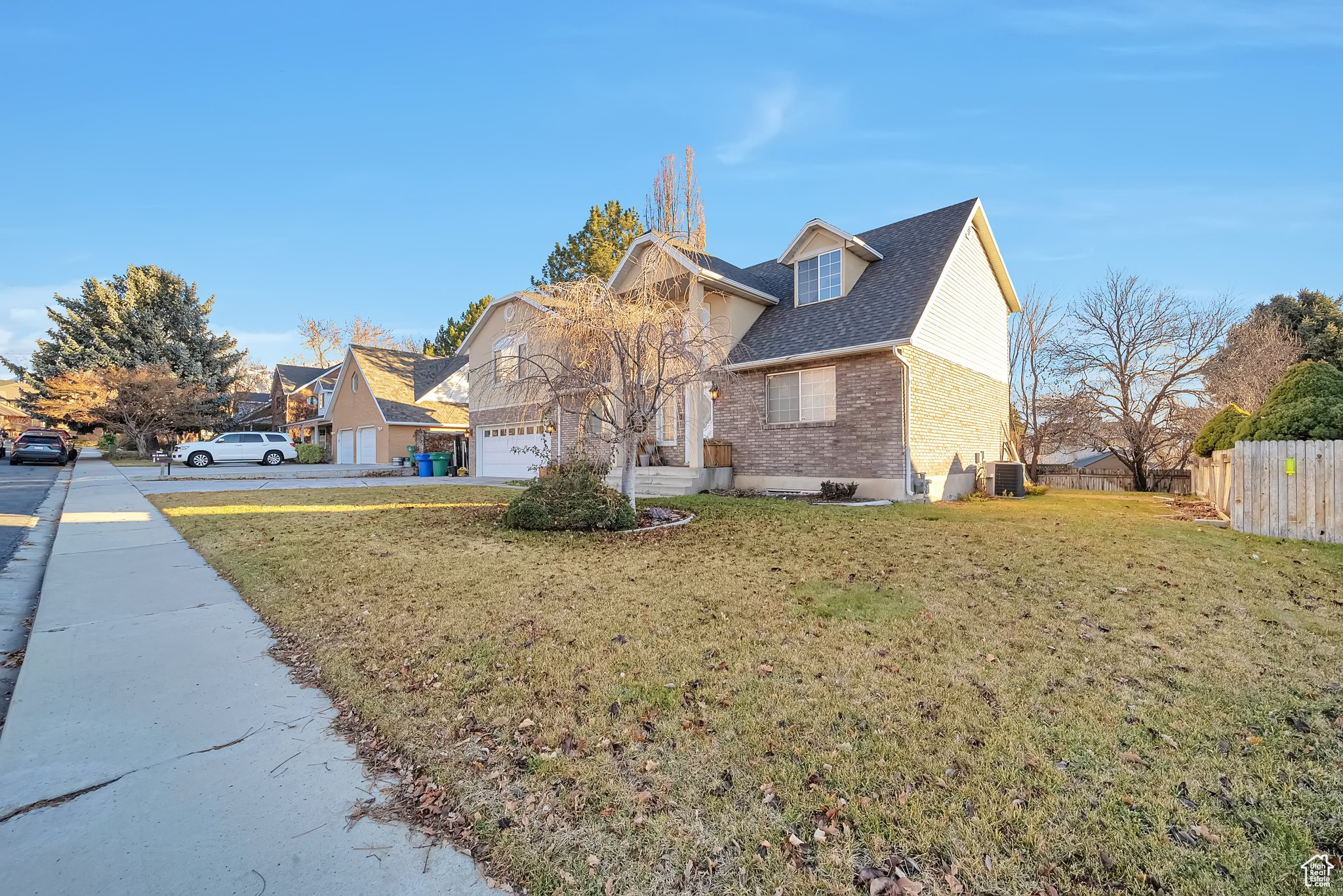 View of home's exterior featuring a yard, cooling unit, and a garage