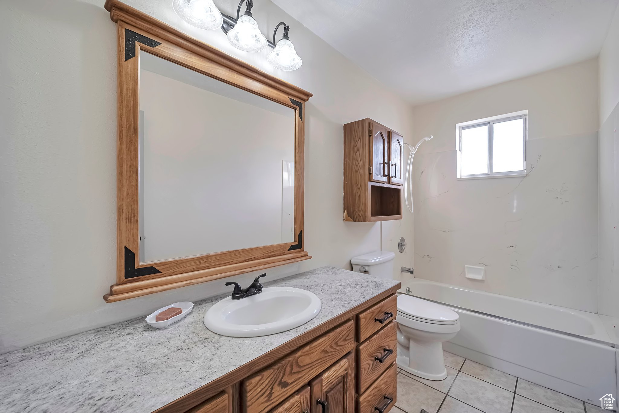 Full bathroom with shower / bathing tub combination, tile patterned flooring, toilet, and vanity