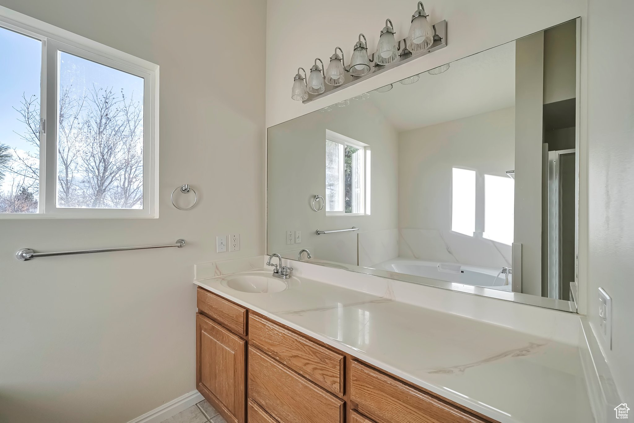 Bathroom featuring a wealth of natural light, vanity, and lofted ceiling