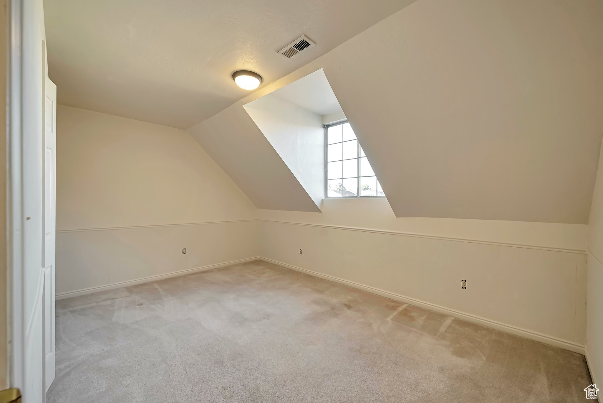 Bonus room with light colored carpet