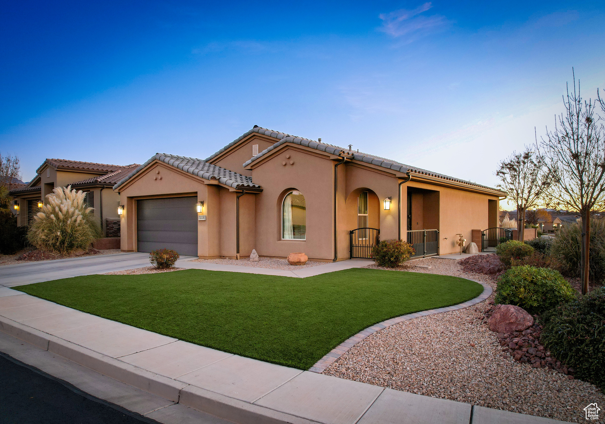 Spanish house featuring a 2 car garage and a turf.