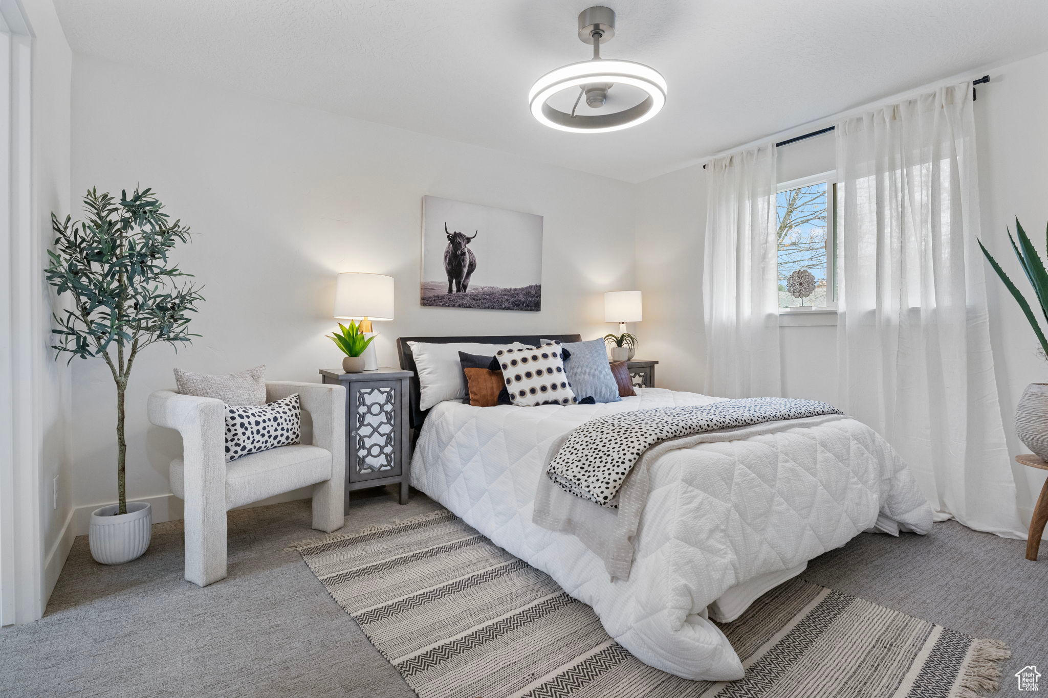 Primary Bedroom featuring carpet floors, ceiling fan, large windows.