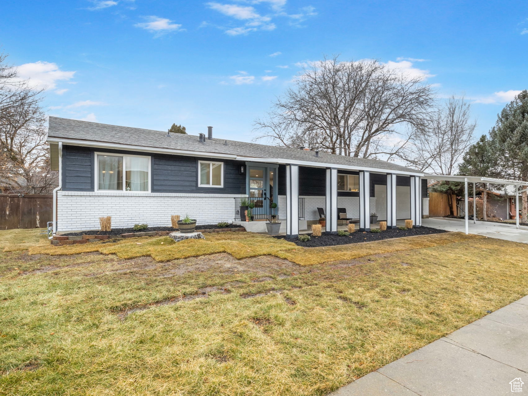 Ranch-style house featuring a carport and a front yard