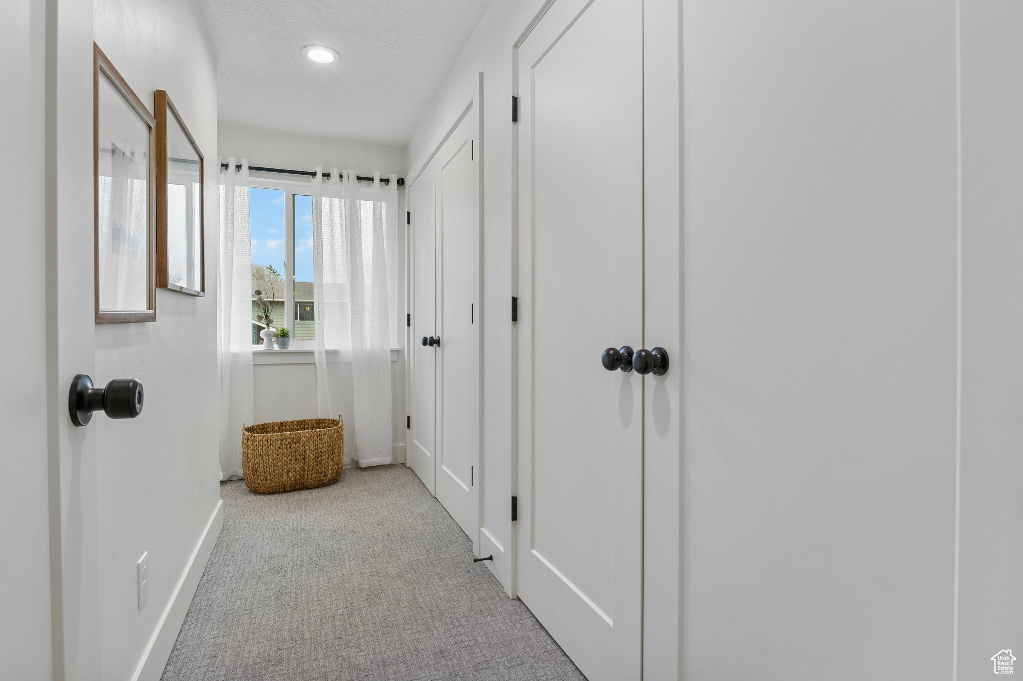 View of hallway leading into primary suite closets