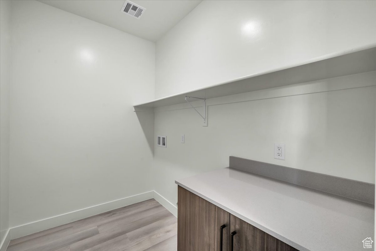 Laundry room featuring washer hookup and light wood-type flooring