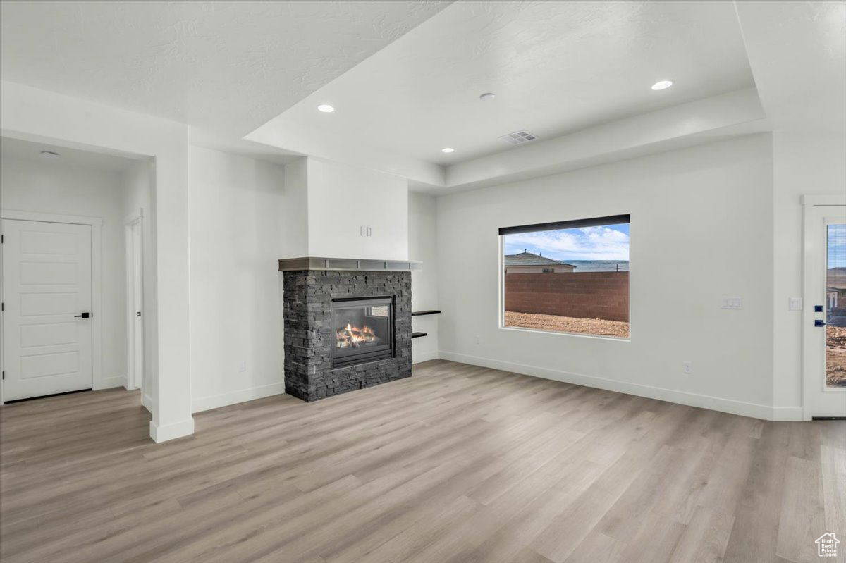 Unfurnished living room featuring a fireplace and light hardwood / wood-style floors