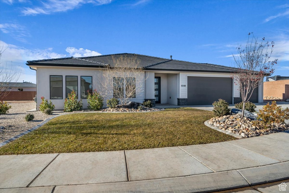 View of front of house featuring a garage and a front lawn