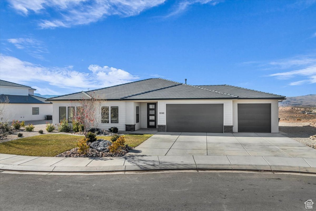 View of front of house with a front yard and a garage