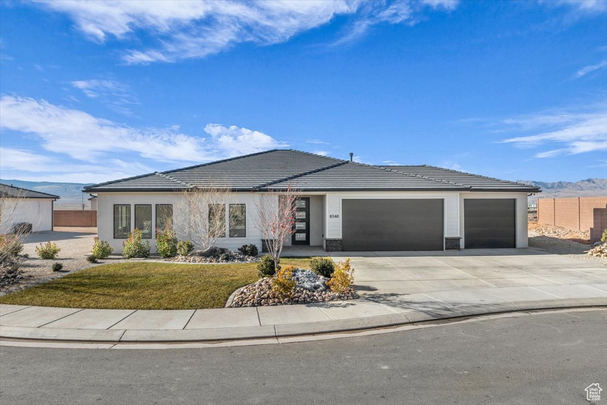 View of front of property with a mountain view, a garage, and a front yard