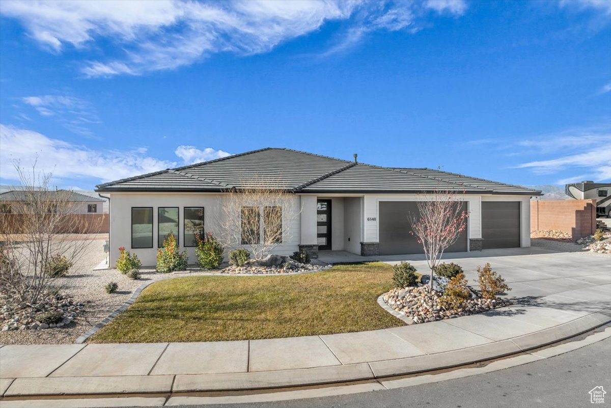 View of front of house with a front lawn and a garage