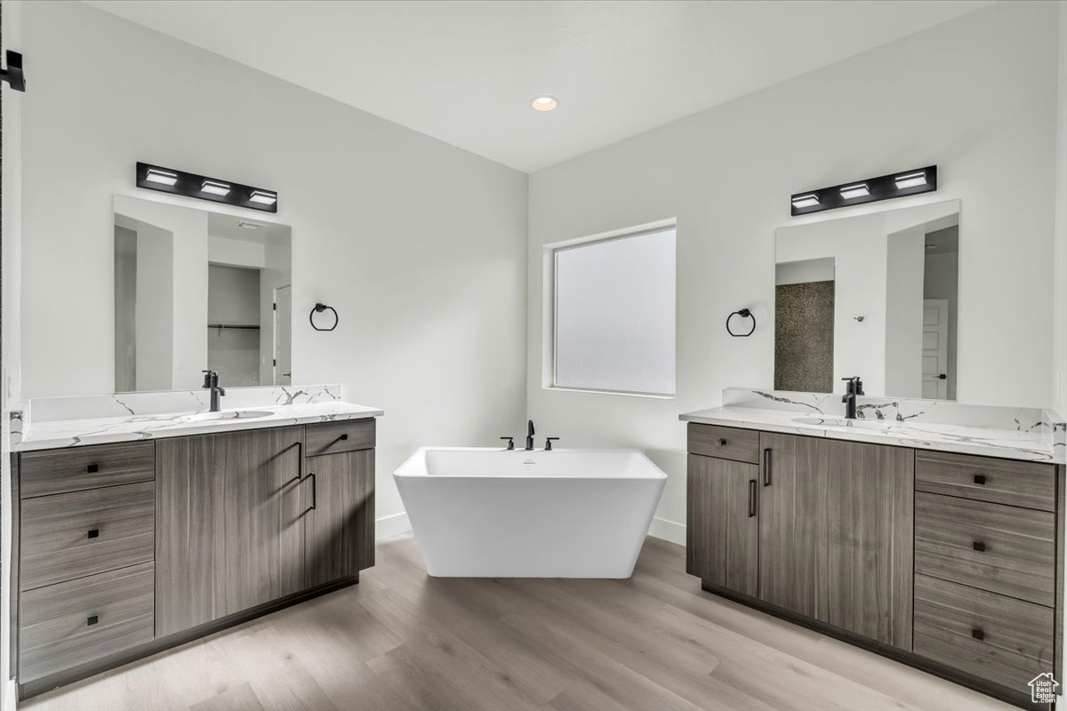 Bathroom featuring hardwood / wood-style floors, a bathtub, and vanity