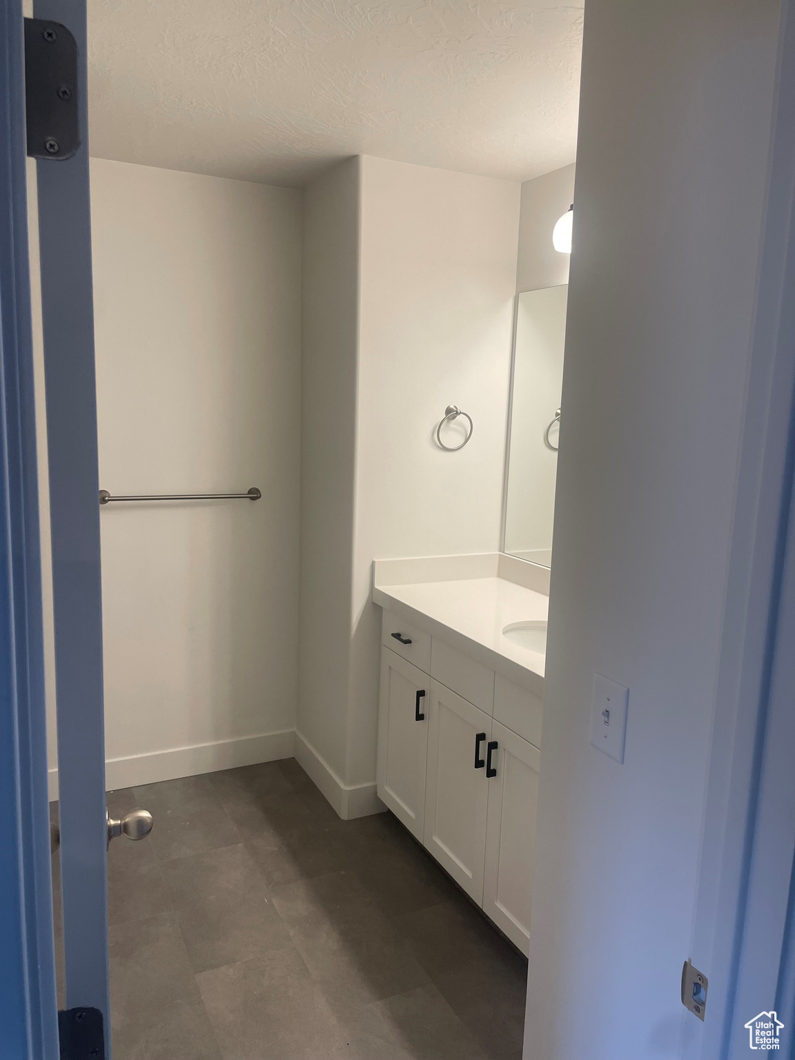 Bathroom with a textured ceiling and vanity