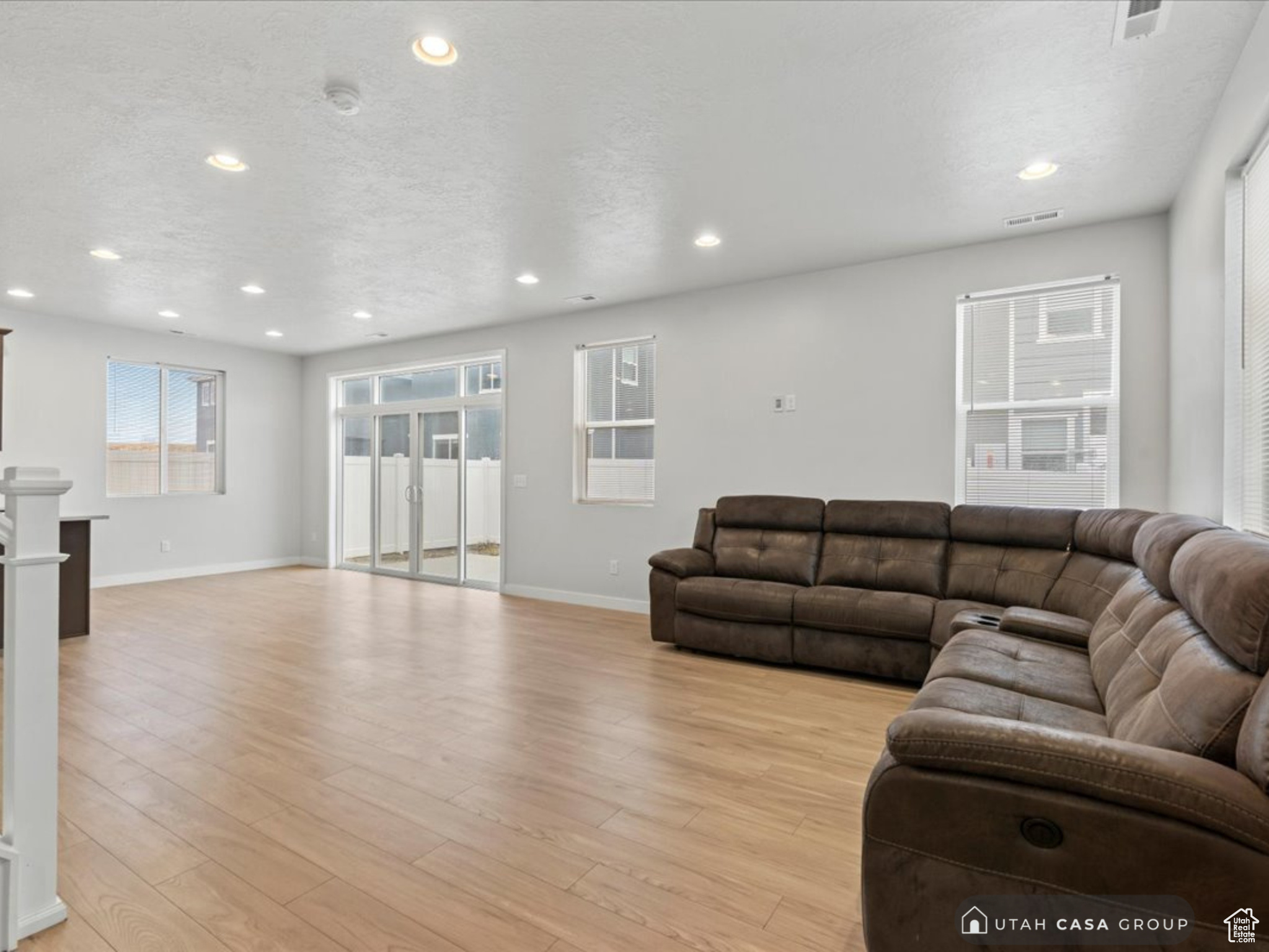 Living room with light wood-type flooring and a textured ceiling