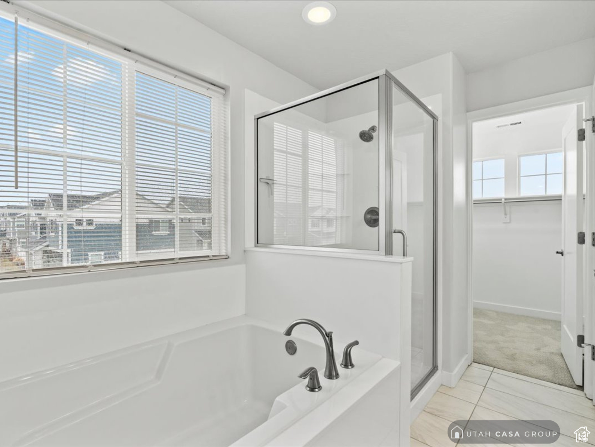 Bathroom with tile patterned floors, a wealth of natural light, and plus walk in shower