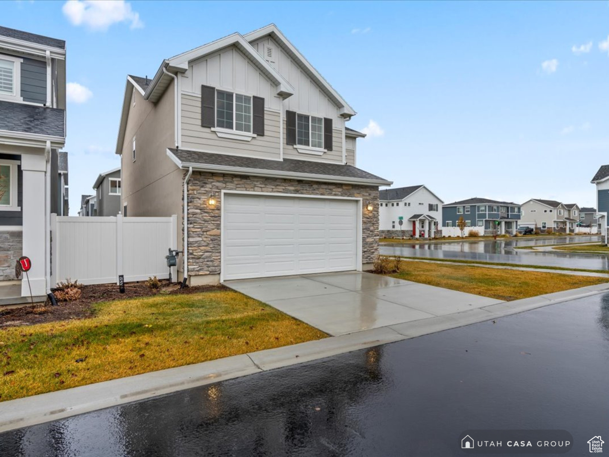 View of front of house featuring a front yard, a water view, and a garage