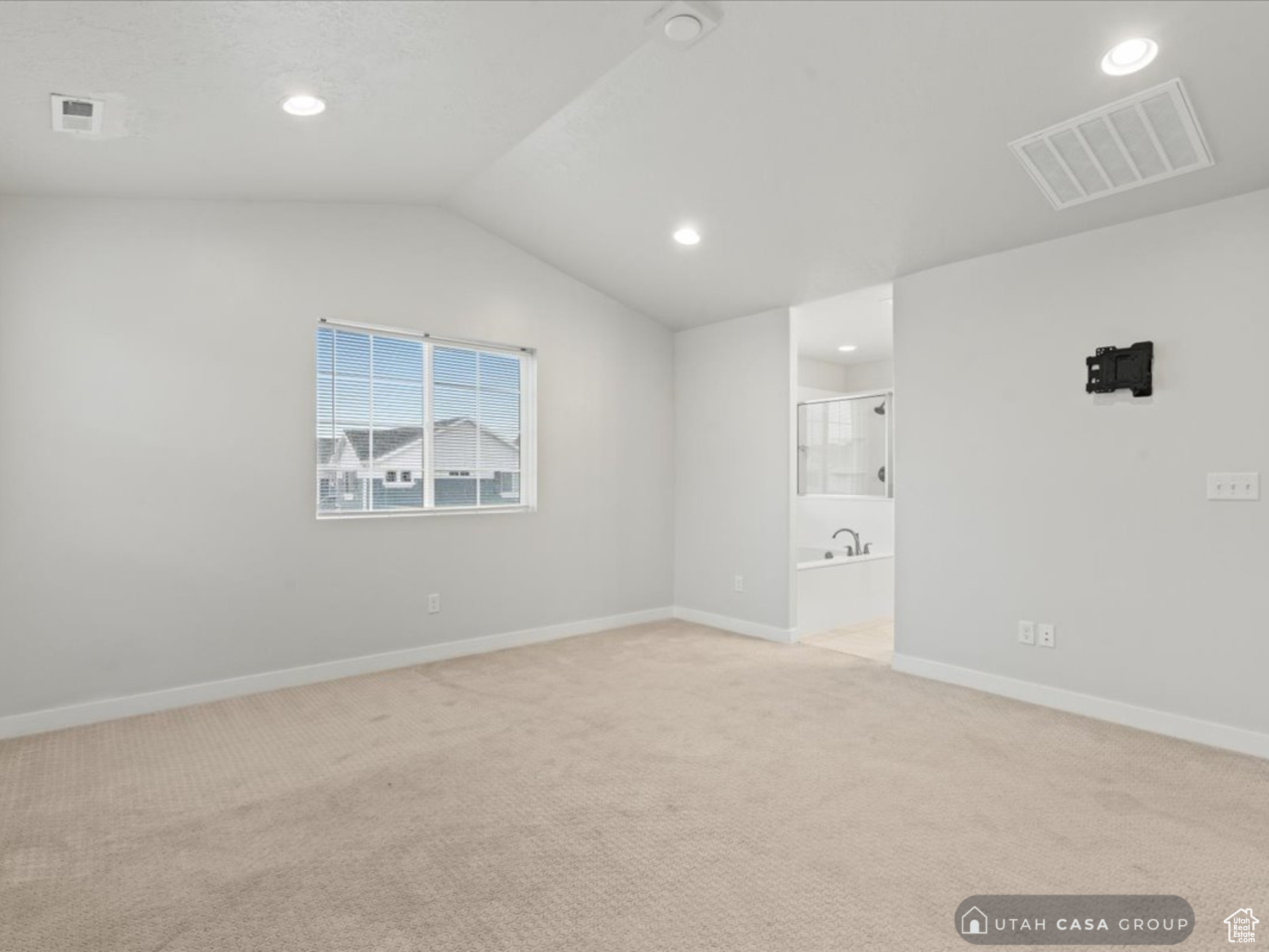 Carpeted empty room with lofted ceiling