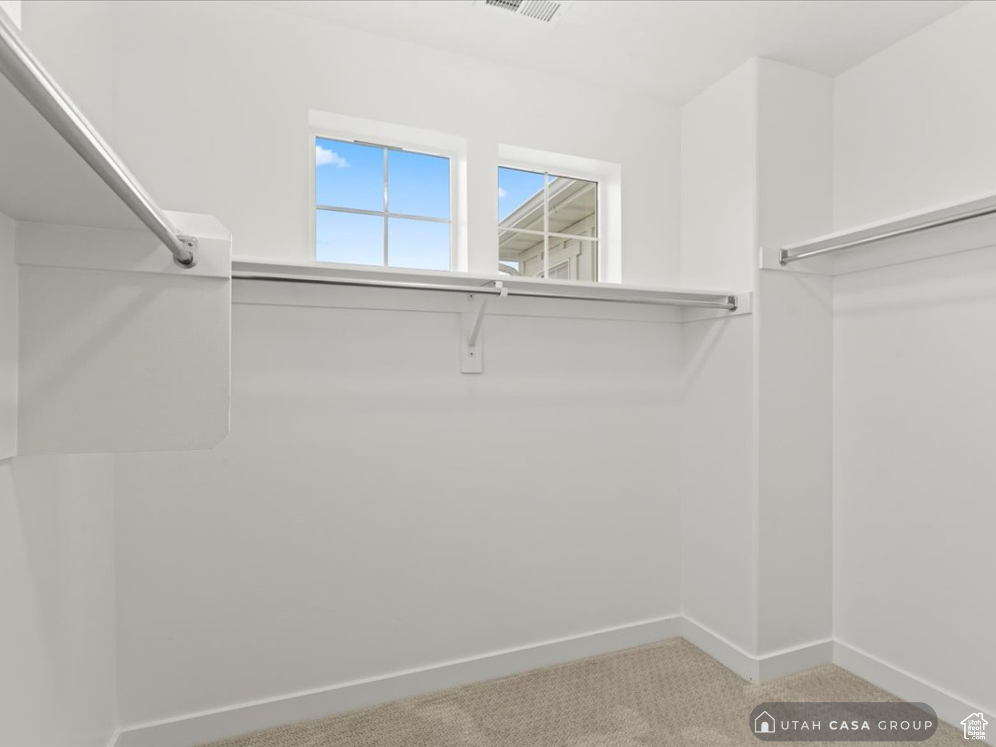 Spacious closet with light carpet