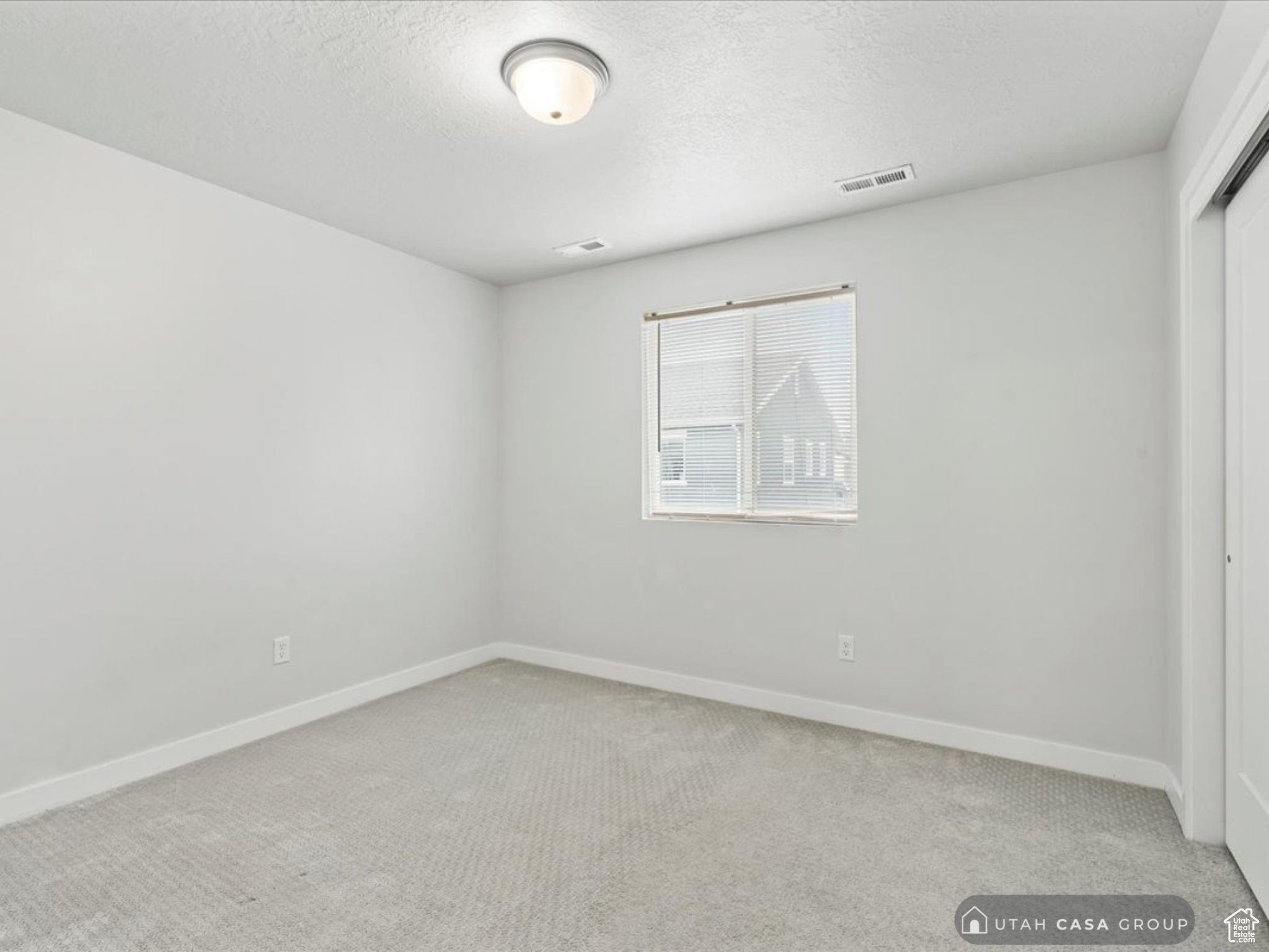 Unfurnished bedroom with light carpet and a closet