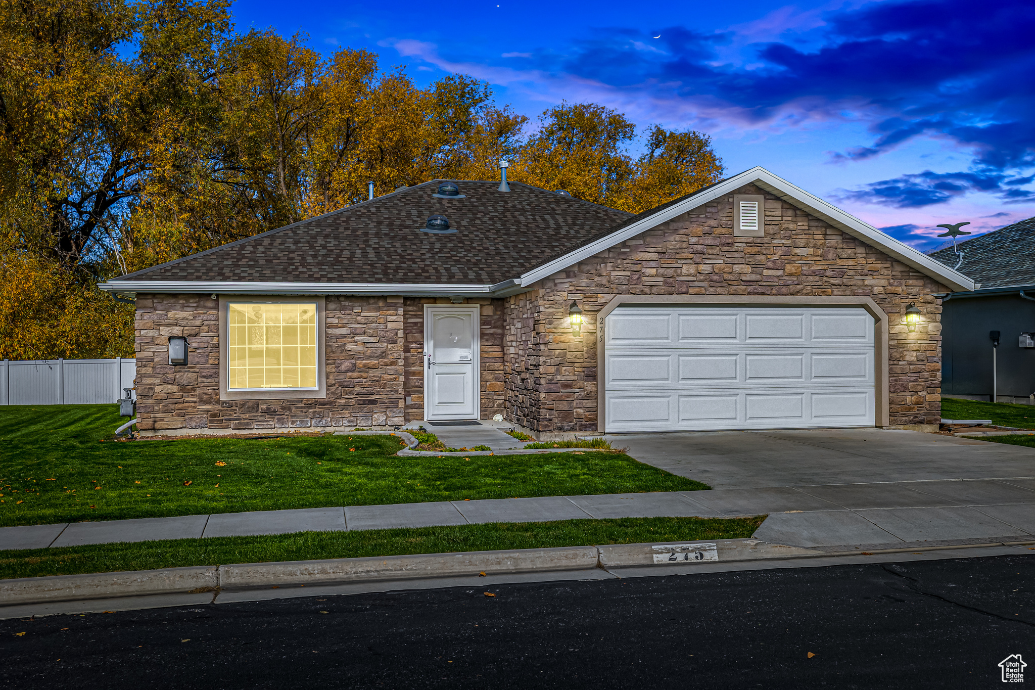 Single story home featuring a lawn and a garage