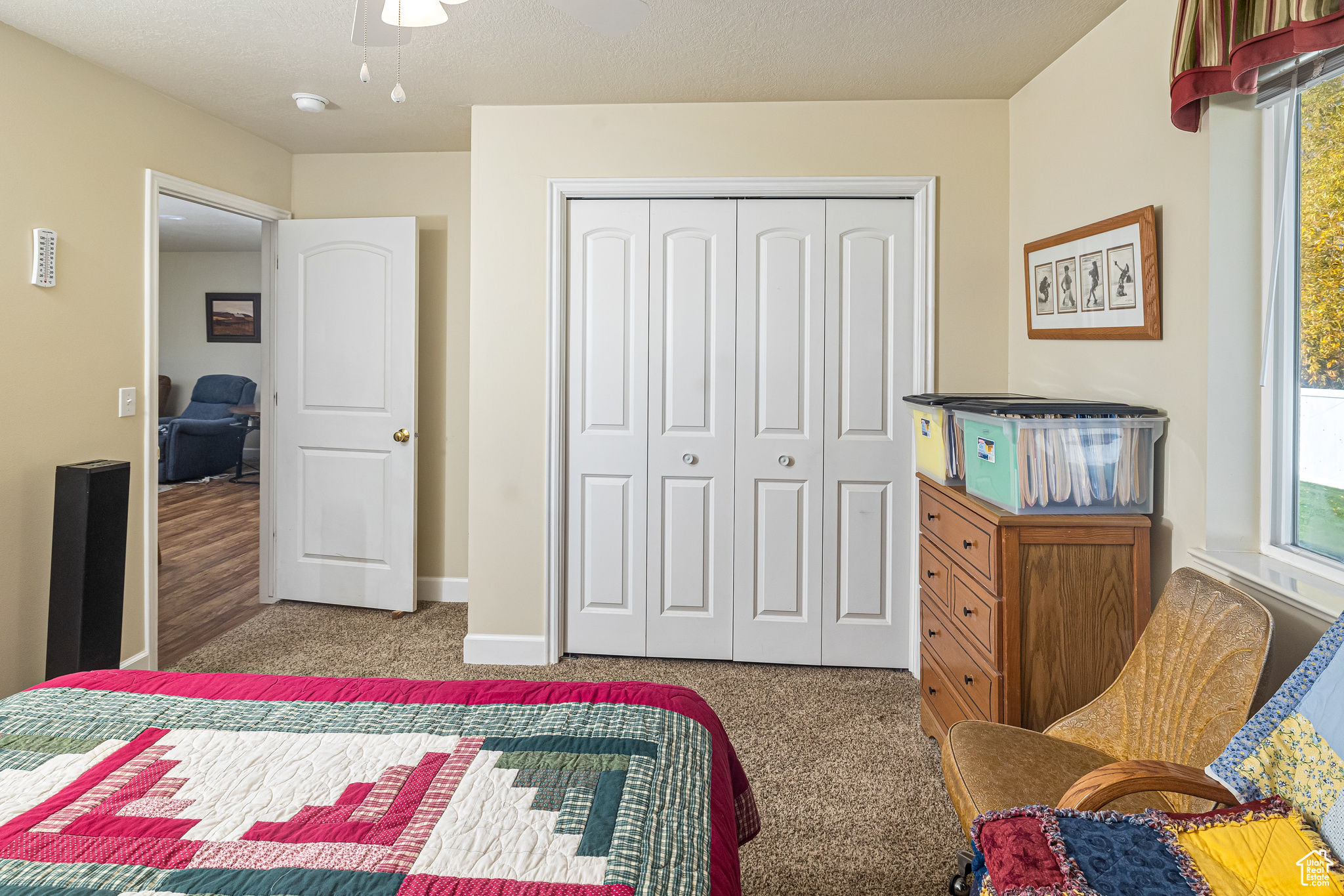 Bedroom featuring ceiling fan, a closet, and light colored carpet