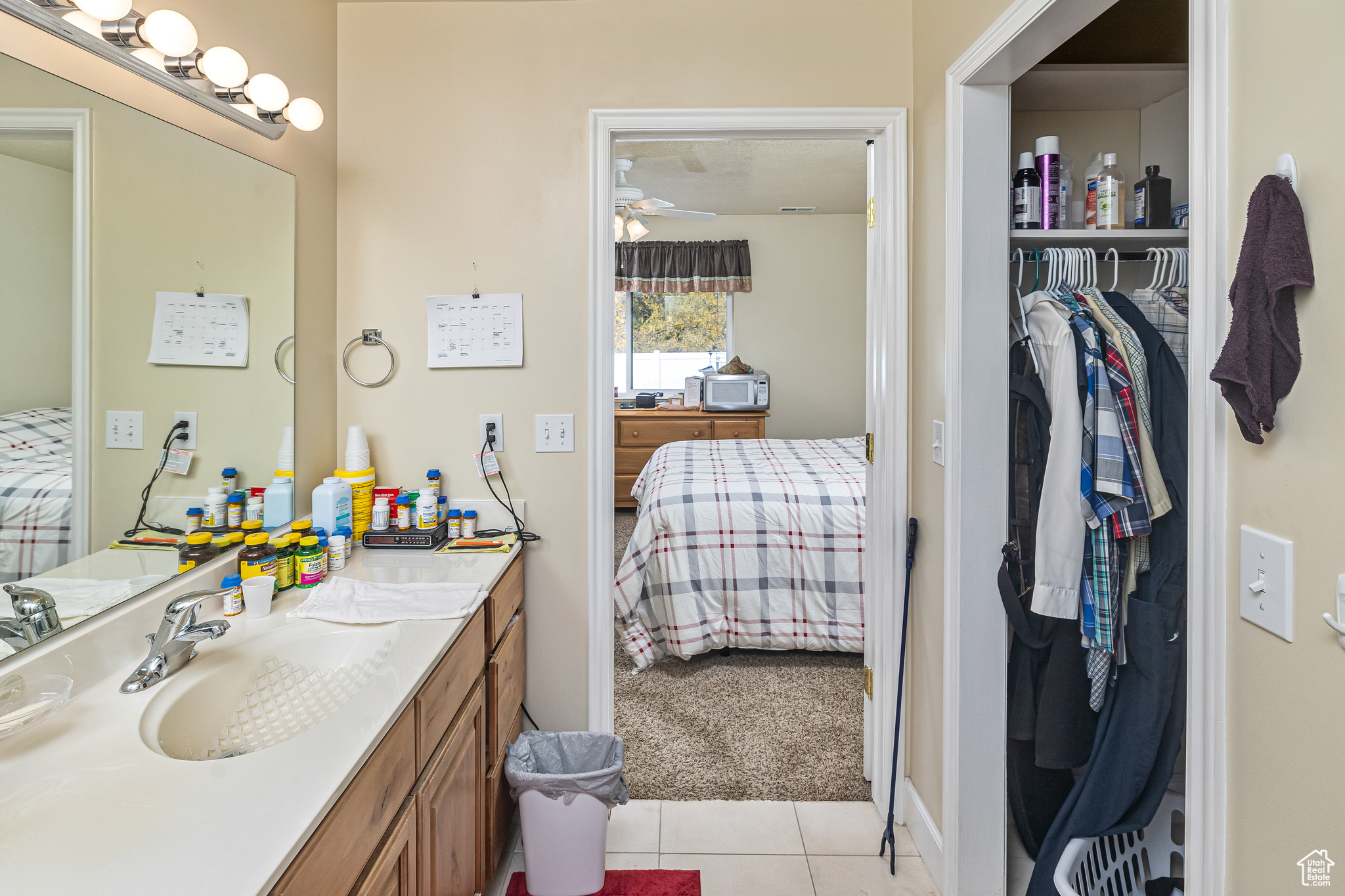 Bathroom with vanity, tile patterned floors, and ceiling fan