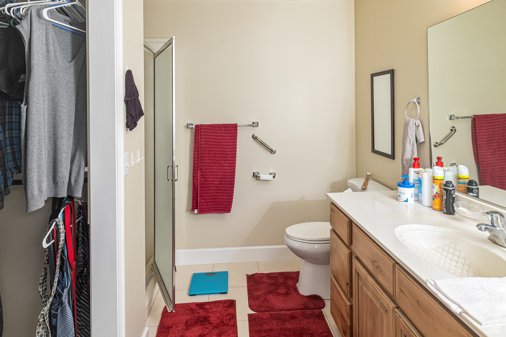 Bathroom with tile patterned floors, vanity, toilet, and walk in shower