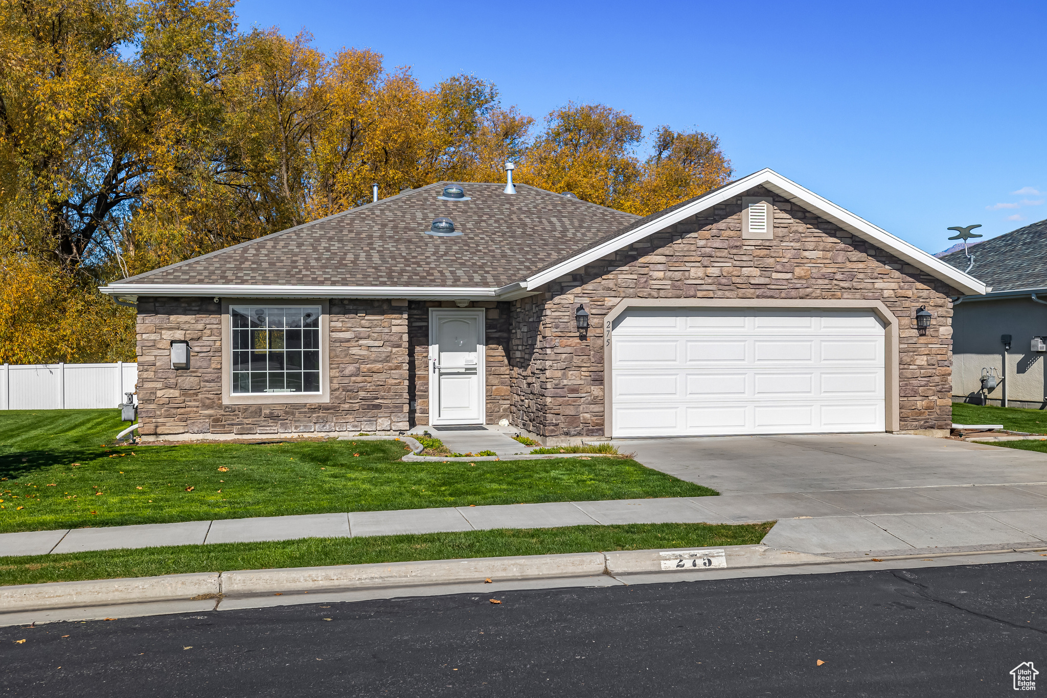 Ranch-style house featuring a garage and a front lawn