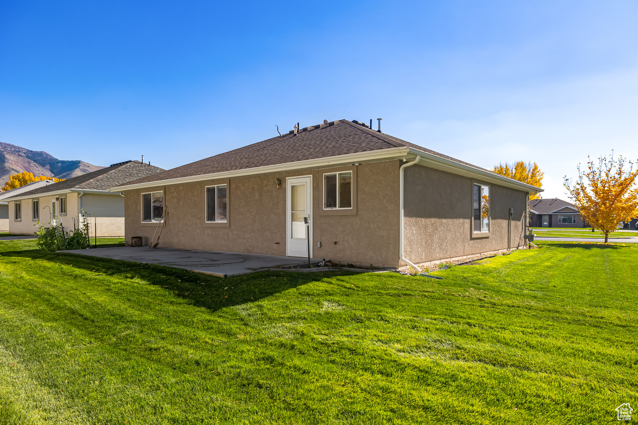 Rear view of house with a patio and a lawn