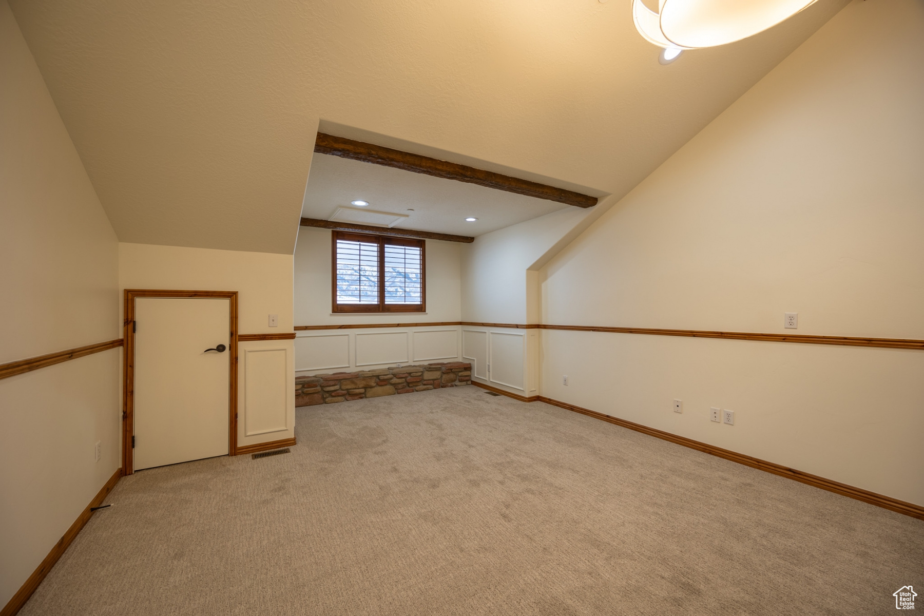 Carpeted empty room with lofted ceiling