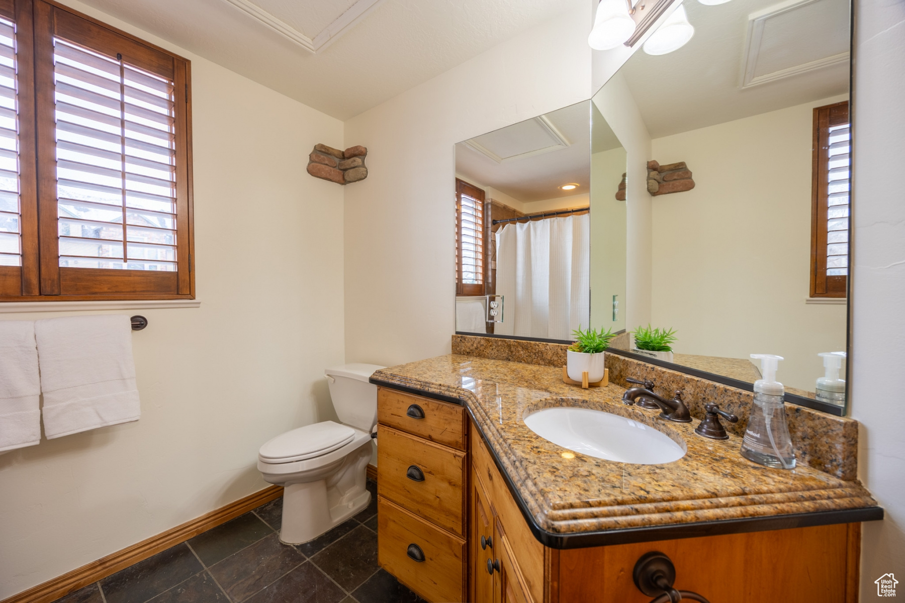 Bathroom with a shower with shower curtain, vanity, and toilet