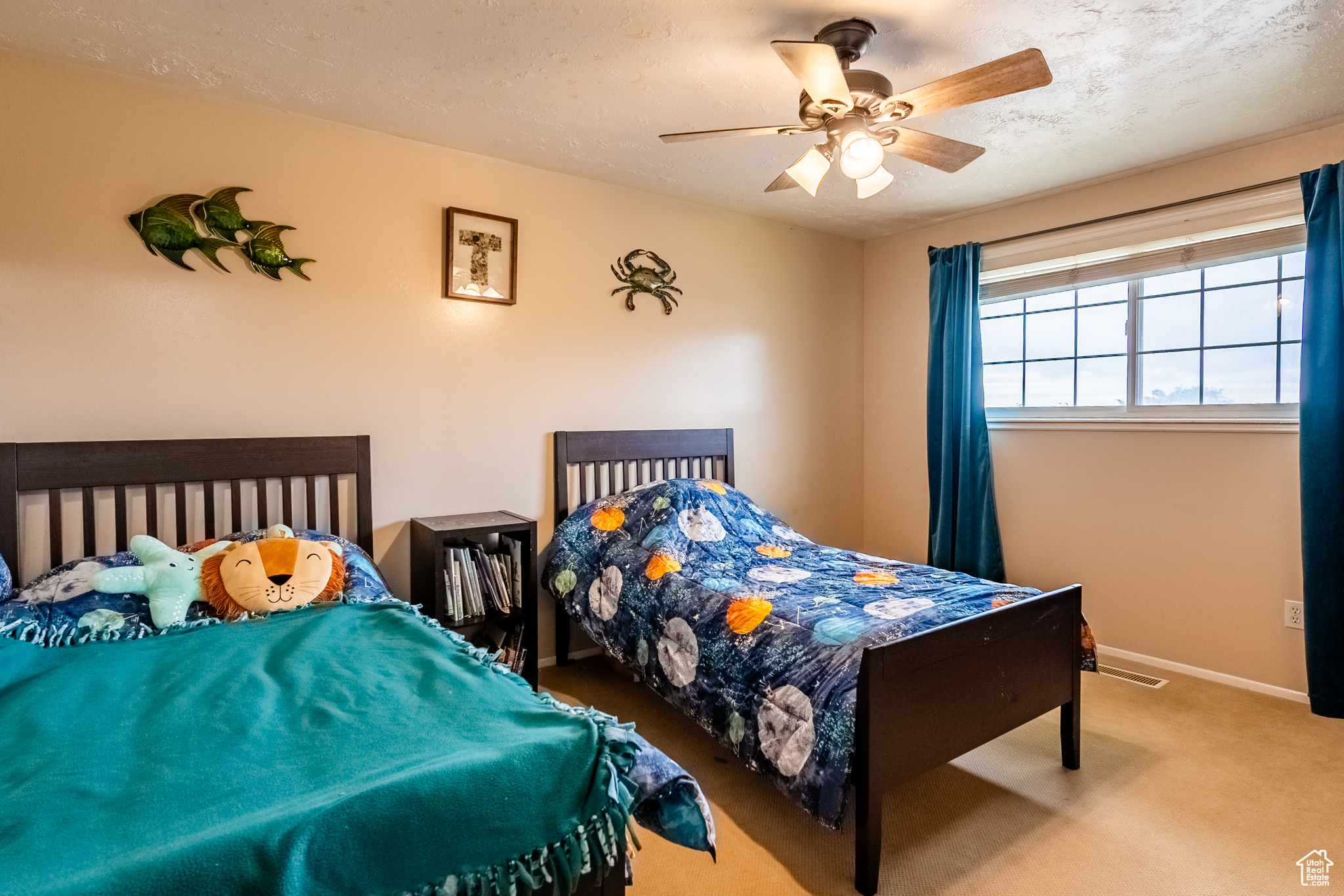 Carpeted bedroom with a textured ceiling and ceiling fan