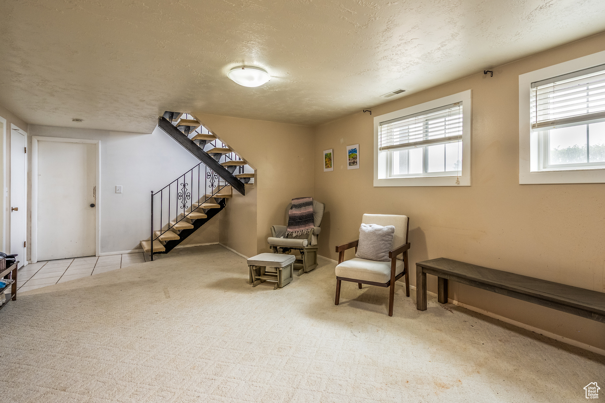 Living area with a textured ceiling and light colored carpet