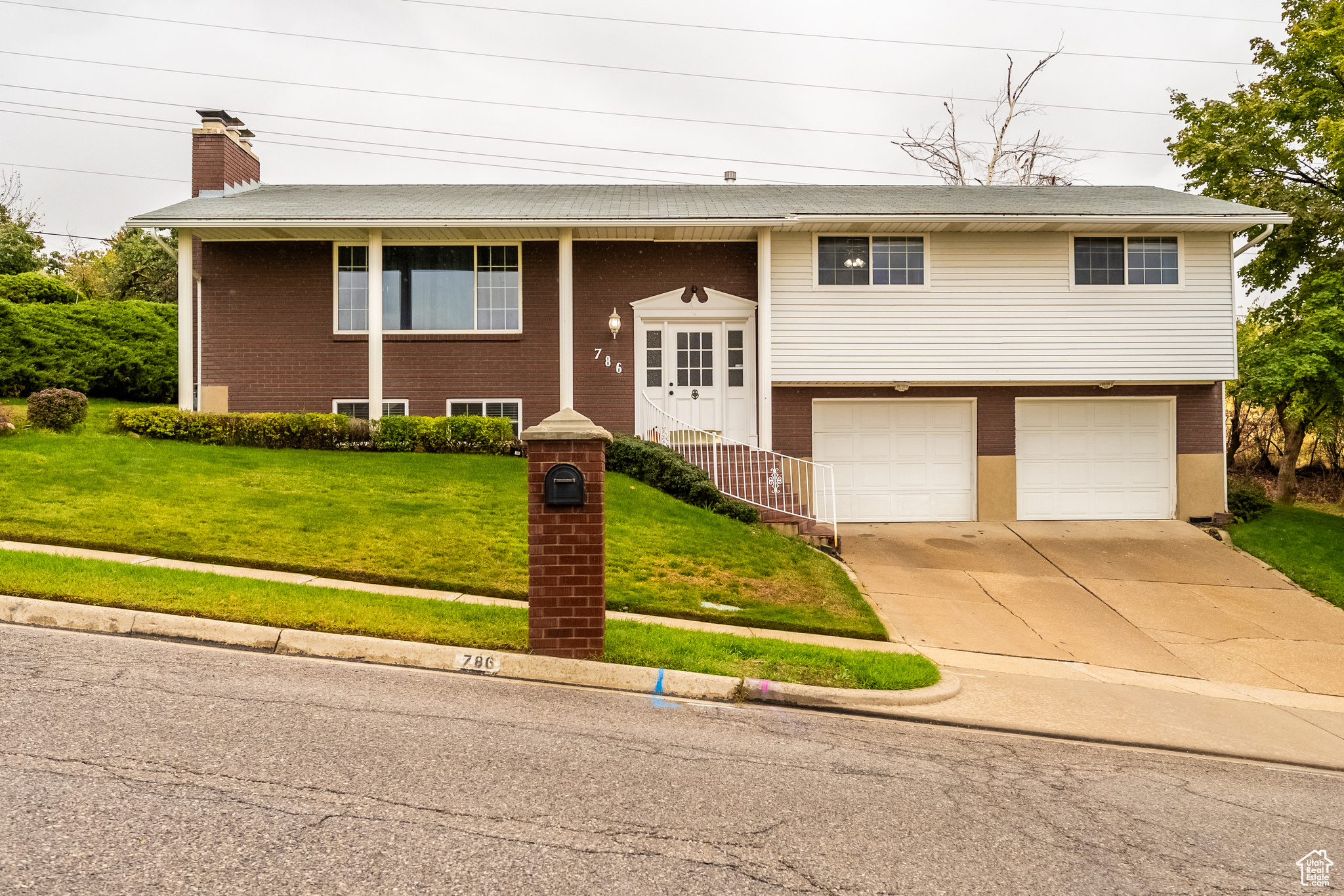 Split foyer home with a garage and a front yard