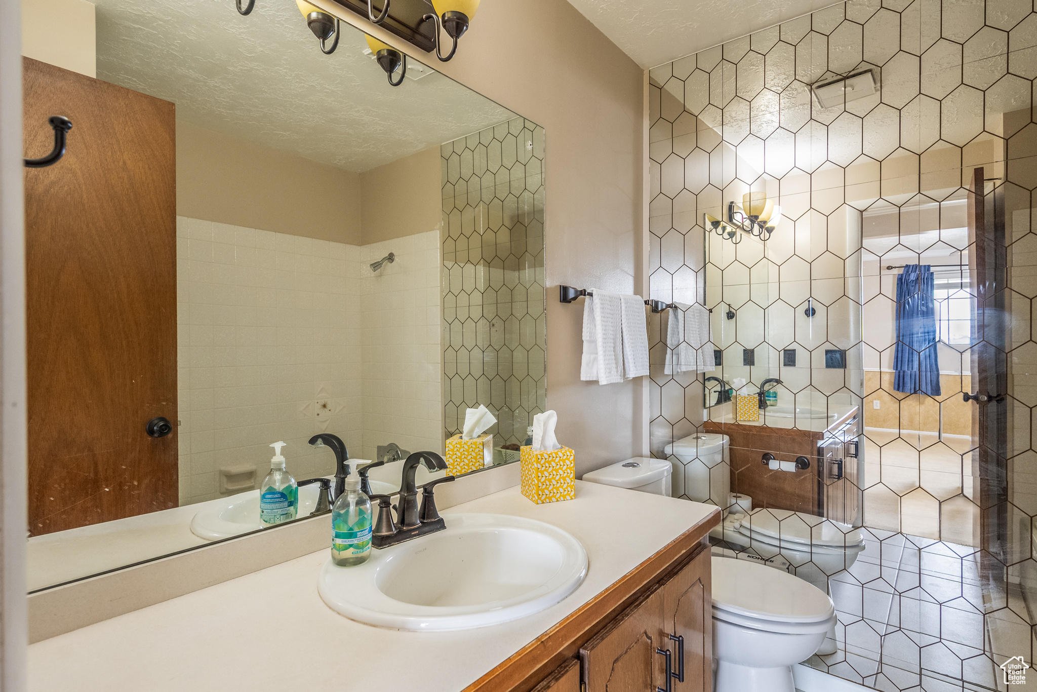 Bathroom featuring a bidet, vanity, a textured ceiling, and toilet