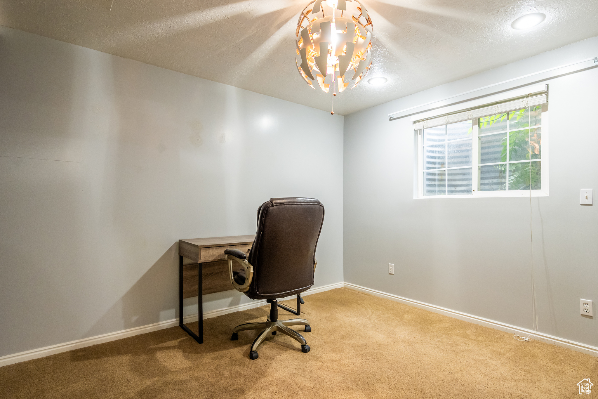 Office area featuring a textured ceiling and light carpet