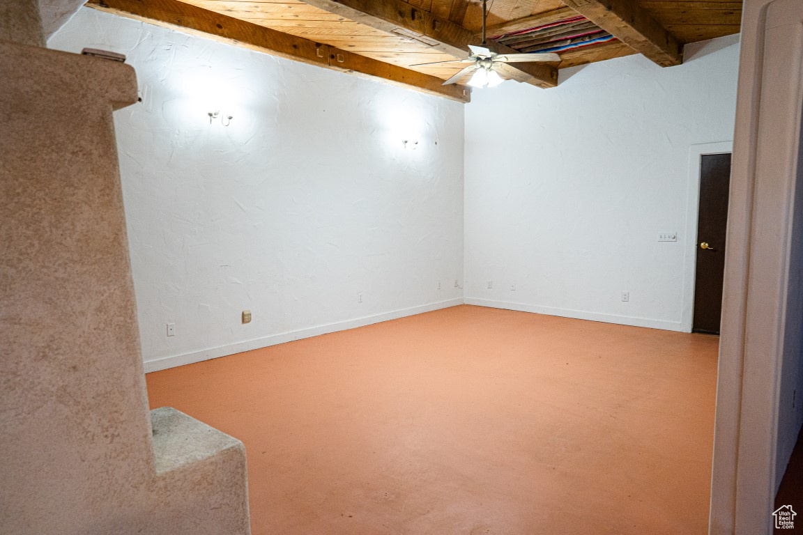 Empty room featuring ceiling fan, beam ceiling, and wood ceiling