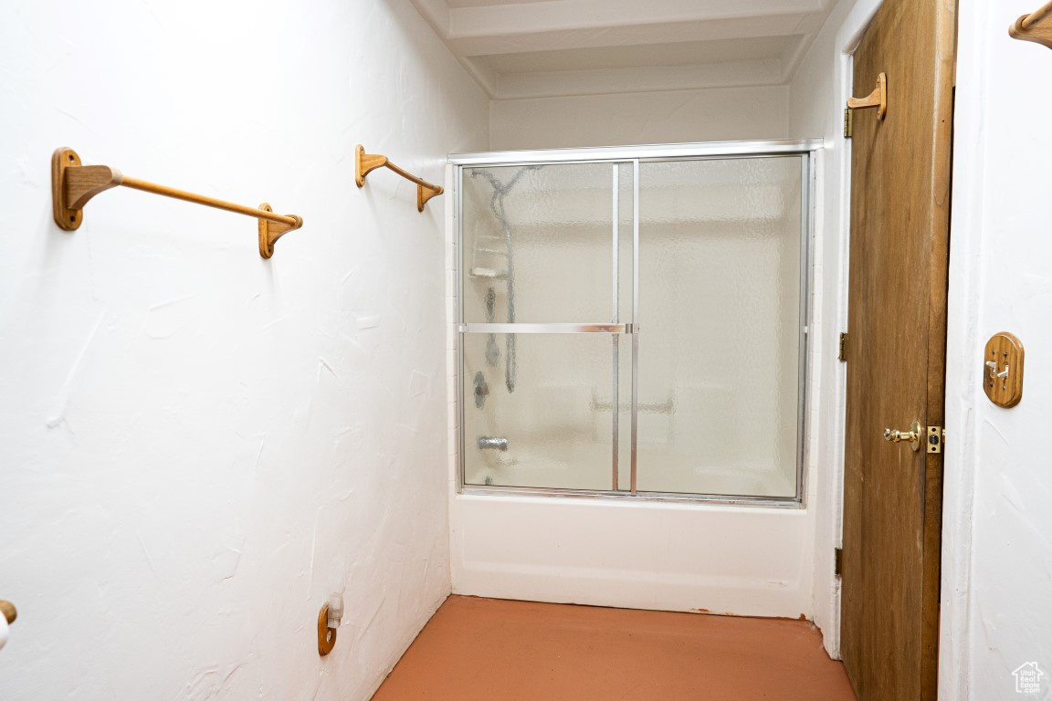 Bathroom with combined bath / shower with glass door