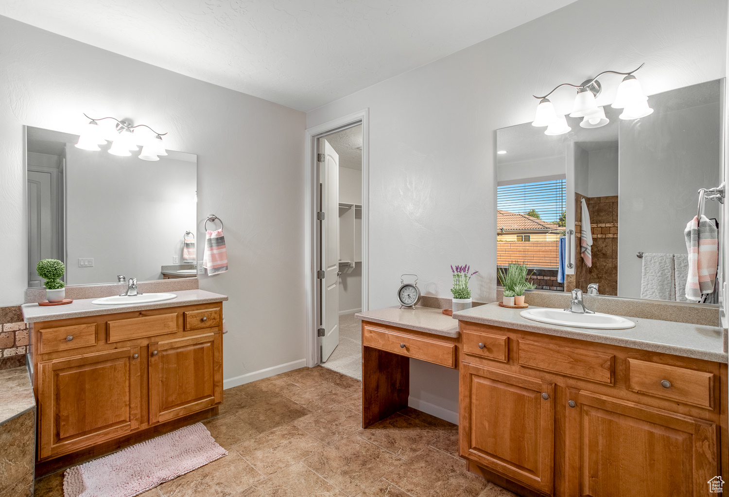 Bathroom with a shower, vanity, and an inviting chandelier