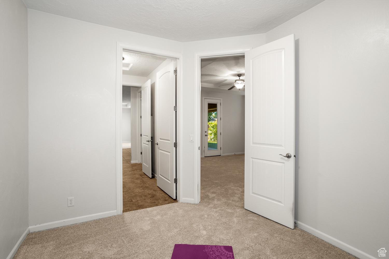 Carpeted empty room with ceiling fan